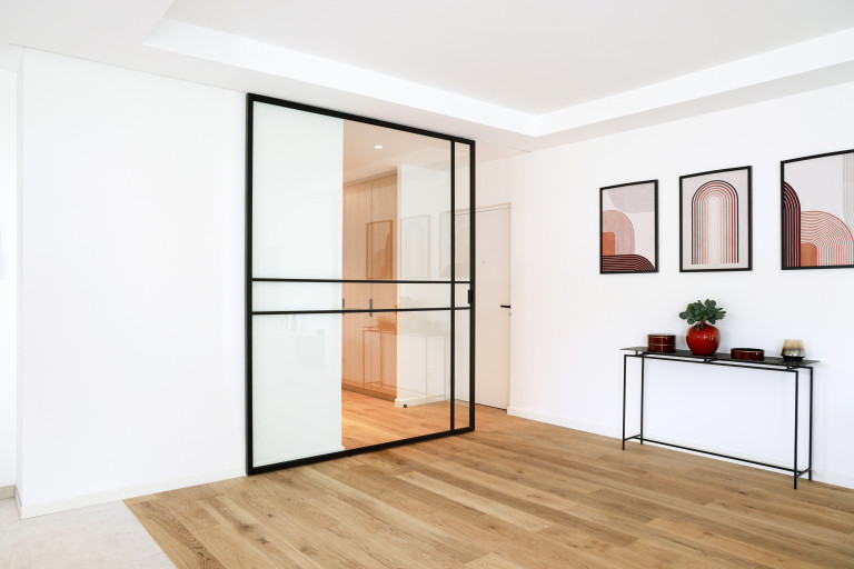 Glazen schuifdeur met zwarte aluminium profielen in steellook en vrij te kiezen traverseprofielen geïnstalleerd in private woning