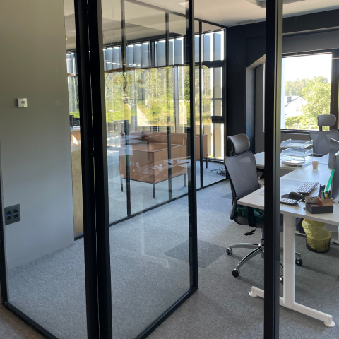 Separador de ambientes en vidrio (pared de vidrio) instalado para separar espacios de oficina. El divina by arlu puede instalarse en cualquier interior.