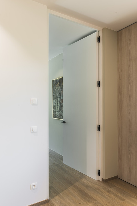 Intégration de charnières invisibles pour les portes en bois au ras du mur.