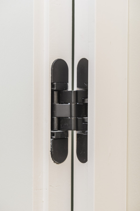 Integration of invisible hinges for wooden doors flush with the wall.