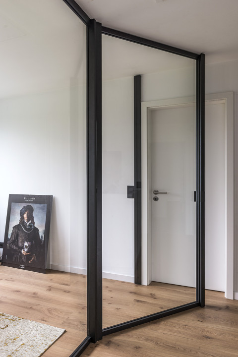 Trennung zwischen Büro und Halle ohne Verlust von Licht und Offenheit dank der divina von ARLU - einer Glastrennwand mit Glasdrehtür