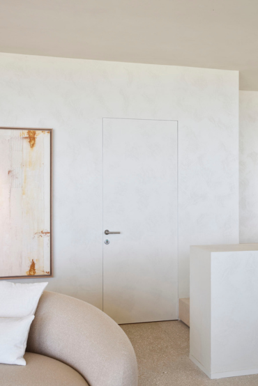 Witte deur onzichtbaar ingewerkt dankzij invisidoor beslag (ARLU). De deur sluit nagenoeg perfect aan op de omliggende muur, waardoor de deur onzichtbaar wordt.